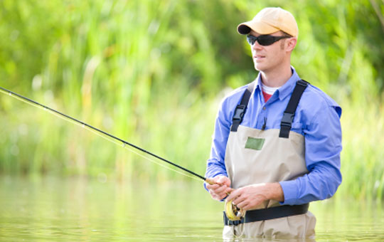 Man wearing sunglasses while he fishes to keep his eyes healthy.